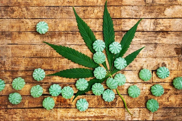 Edibles - cannabis candies on table with leaf 600x398